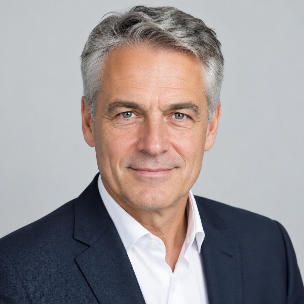 Studio portrait of an older man with gray hair and a suit jacket