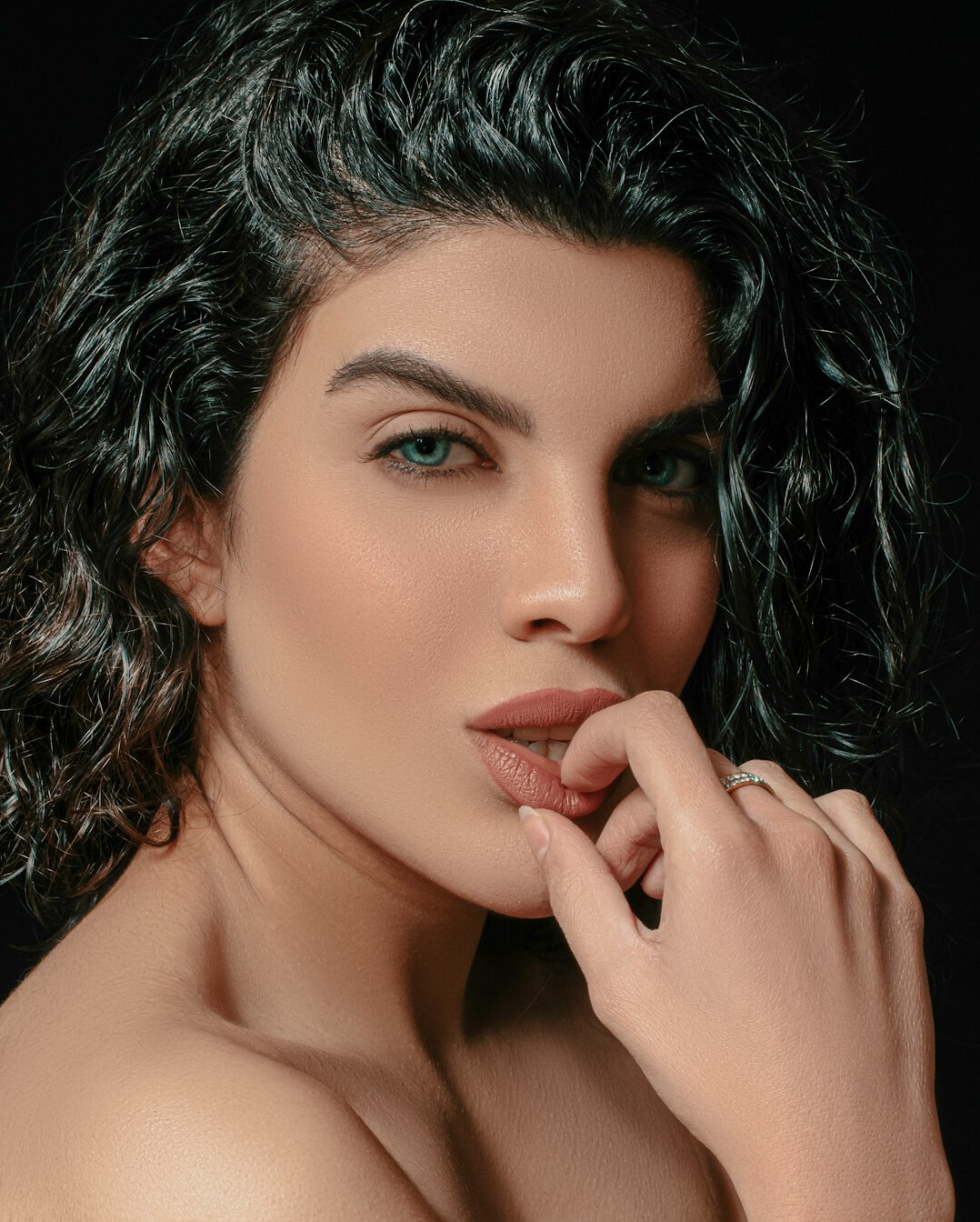 Studio portrait of a woman with dark curly hair